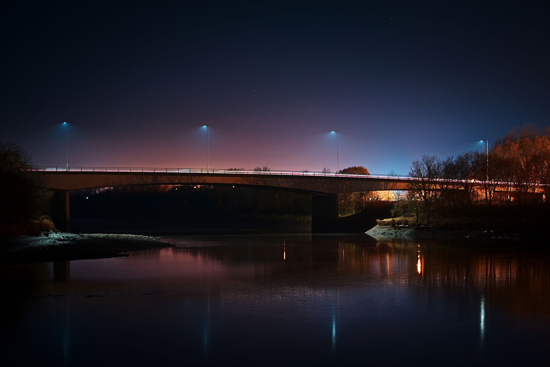 Nocny most nad spokojną rzeką Han oświetlony miejskimi światłami