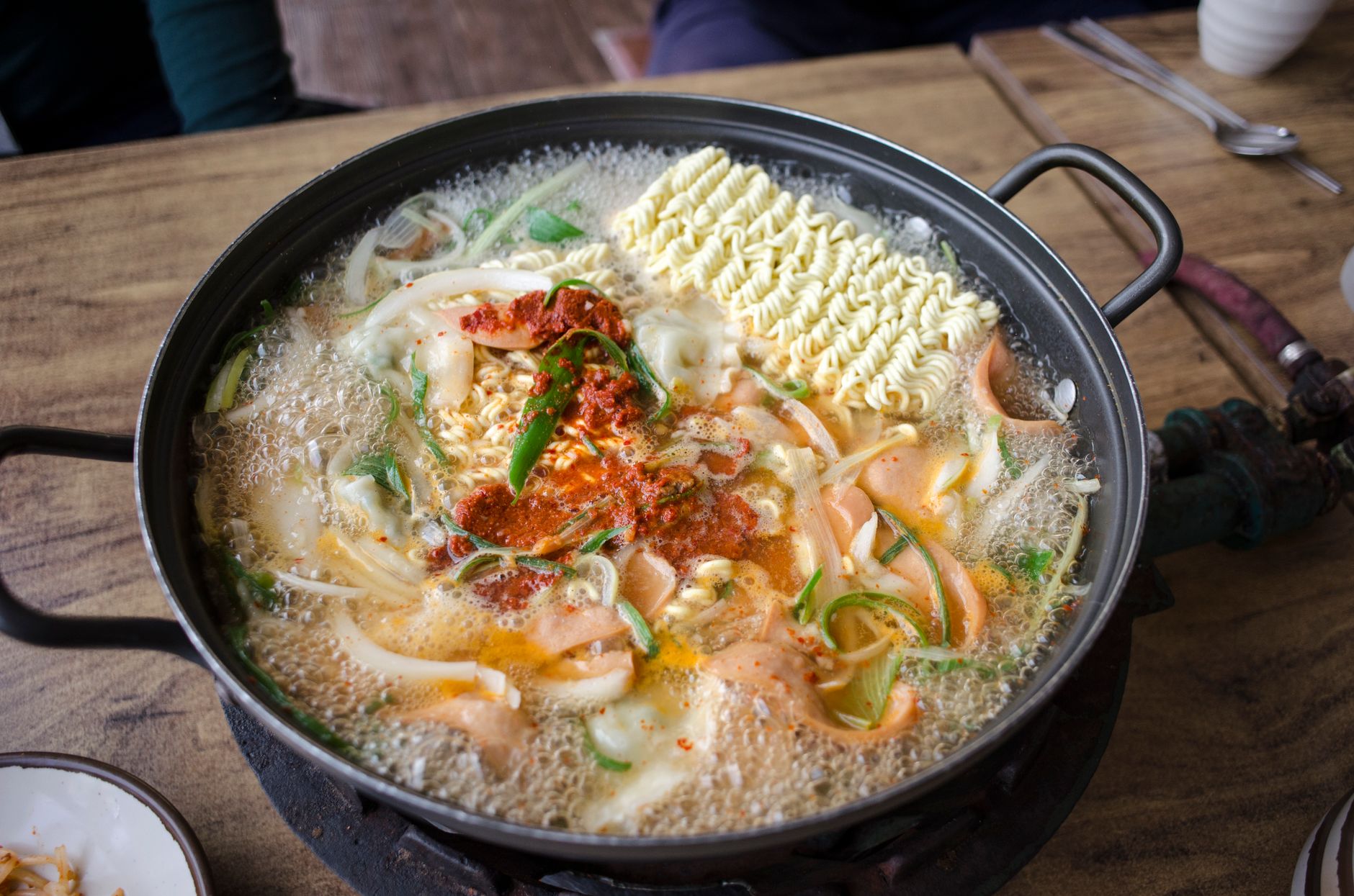 Pikantny koreański ramen z warzywami gotujący się w rondlu