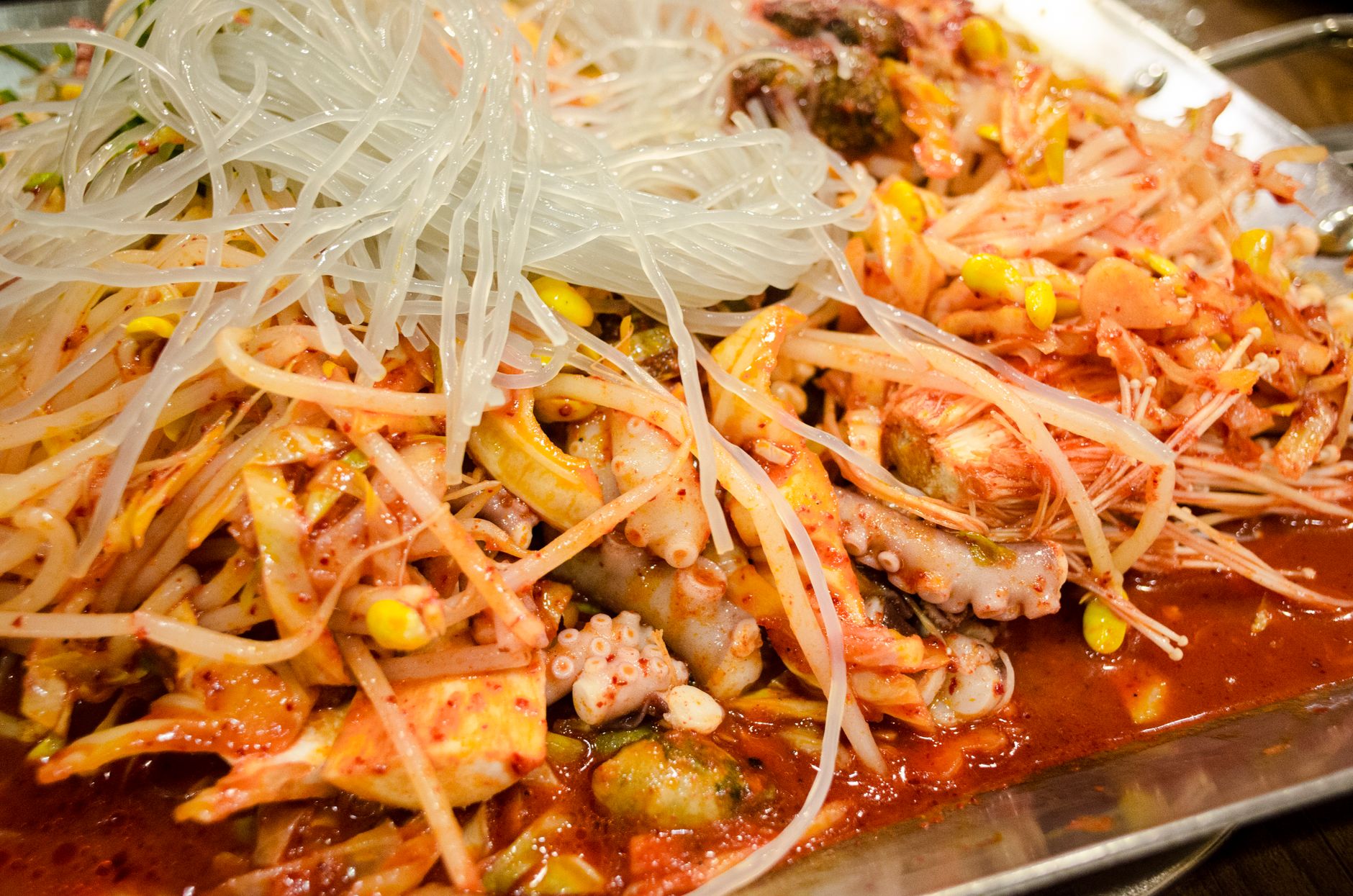 Zbliżenie na koreańskie danie z owocami morza, makaronem i kimchi