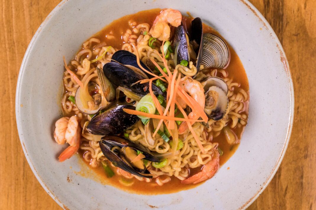 Zbliżenie na miskę koreańskiego ramen z owocami morza i warzywami