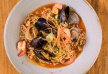 Kultura jedzenia solo w Korei: co mówią o społeczeństwie bary gimbap i ramen Zbliżenie na miskę koreańskiego ramen z owocami morza i warzywami